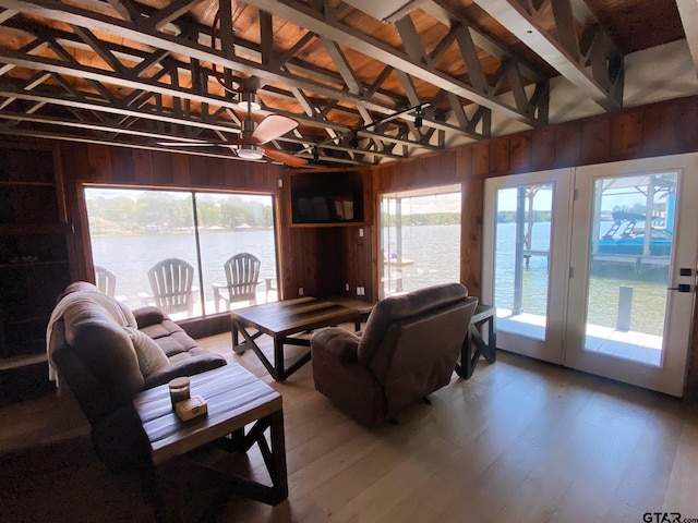 living room with lofted ceiling with beams, wood walls, and a wealth of natural light