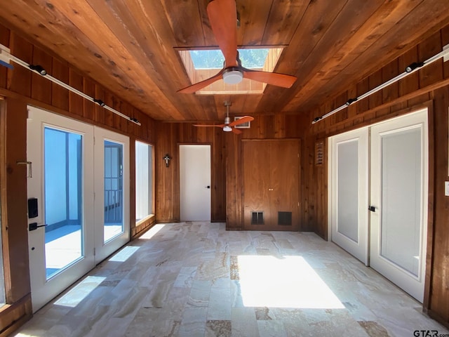 interior space with a skylight, ceiling fan, french doors, and wood ceiling