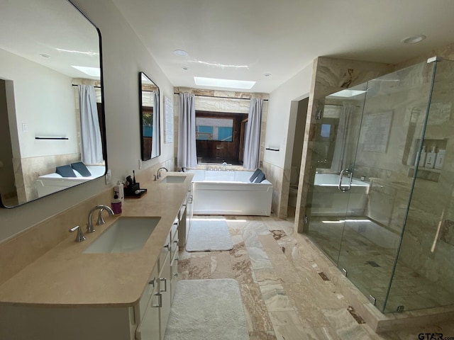 bathroom with vanity, separate shower and tub, and a skylight