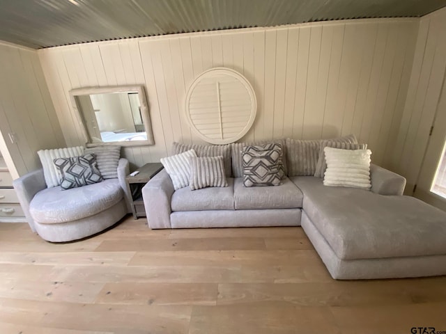 living room with light wood-type flooring, wooden walls, and wood ceiling