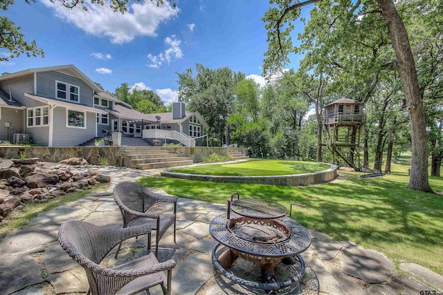 view of patio featuring central AC unit and a fire pit