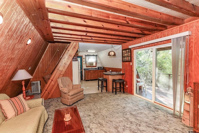 carpeted living room featuring wood walls, radiator heating unit, and vaulted ceiling