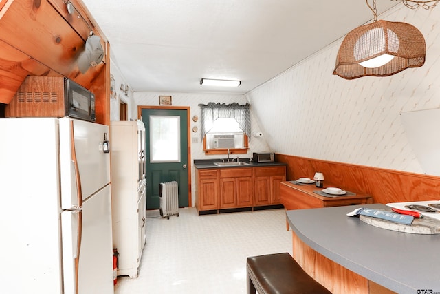 kitchen featuring lofted ceiling, radiator, white refrigerator, cooling unit, and sink