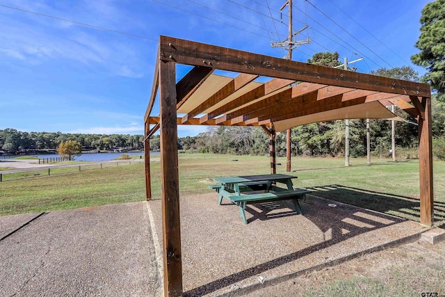 view of property's community with a yard, a water view, a patio, and a pergola