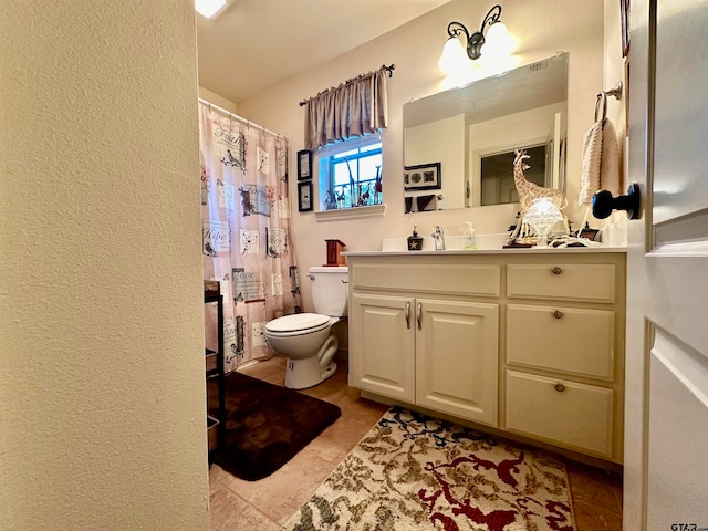 bathroom with tile patterned flooring, vanity, and toilet