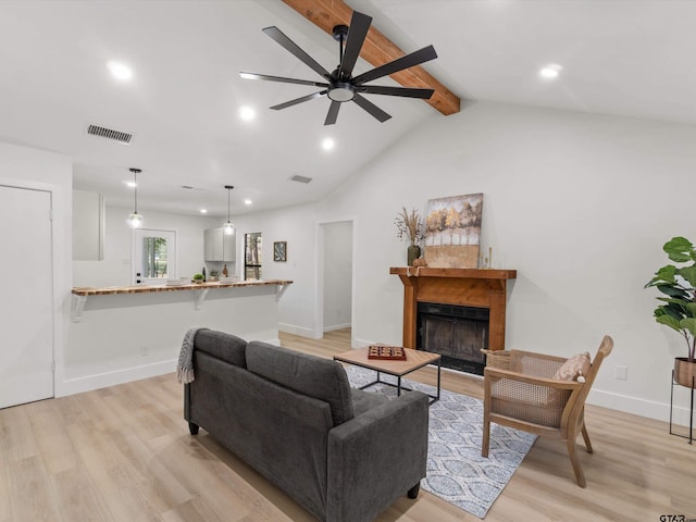 living room featuring light wood-type flooring, vaulted ceiling with beams, and ceiling fan