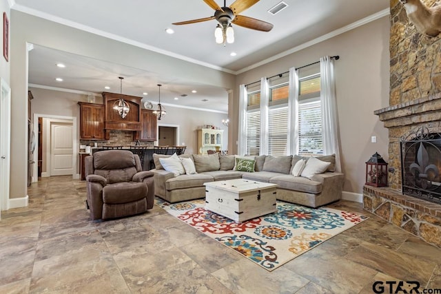 living room with a fireplace, ceiling fan, and ornamental molding