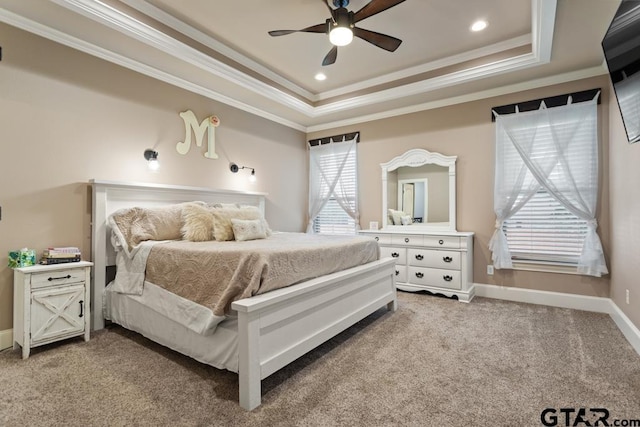 bedroom with ceiling fan, a raised ceiling, carpet floors, and ornamental molding