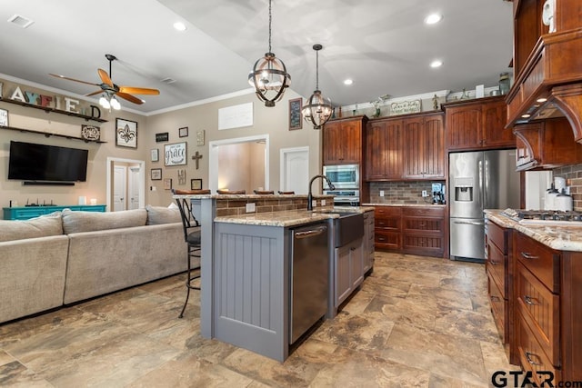 kitchen featuring light stone counters, ornamental molding, an island with sink, and stainless steel appliances