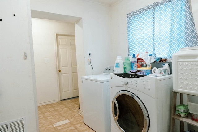 washroom featuring washer and clothes dryer and ornamental molding