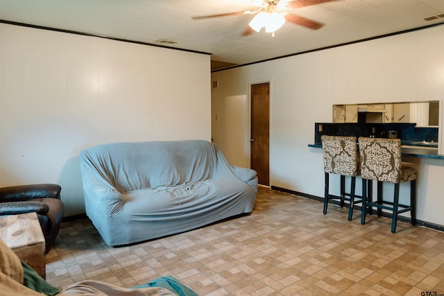 living room featuring ceiling fan and ornamental molding