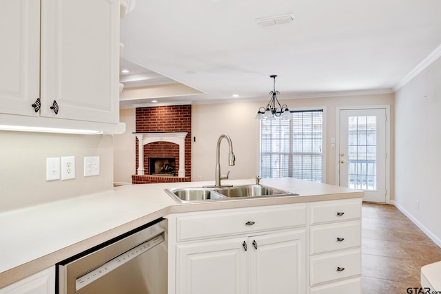 kitchen featuring white cabinetry, dishwasher, sink, a brick fireplace, and pendant lighting