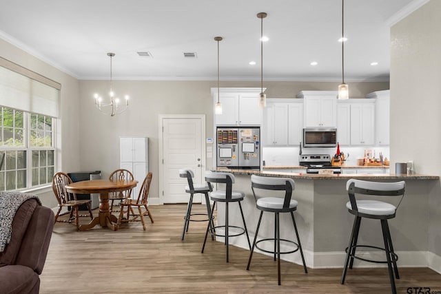 607 Main St, Bullard, TX 75757 - kitchen with appliances with stainless steel finishes, stone countertops, a kitchen bar, white cabinetry, and crown molding