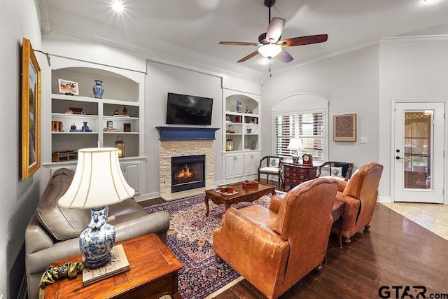 4133 Colina Trl, Tyler, TX 75707 - living area featuring crown molding, a stone fireplace, ceiling fan, built in features, and wood finished floors