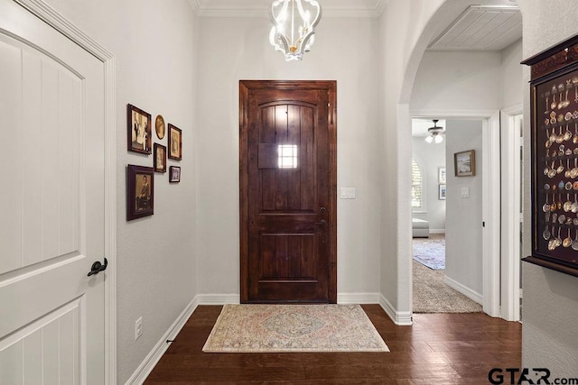 4133 Colina Trl, Tyler, TX 75707 - entryway featuring arched walkways, dark wood-type flooring, a chandelier, ceiling fan, and crown molding