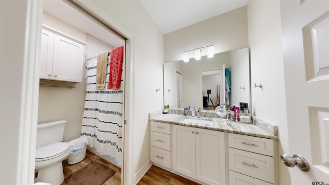 bathroom featuring hardwood / wood-style floors, toilet, curtained shower, and vanity