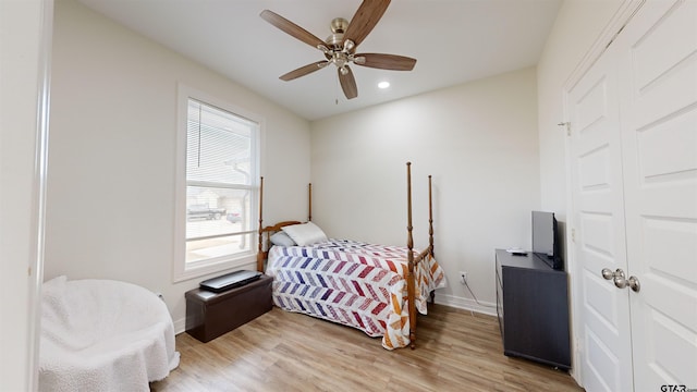 bedroom with a closet, ceiling fan, light hardwood / wood-style flooring, and multiple windows