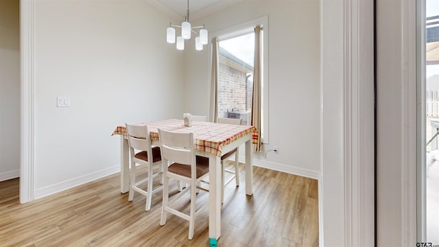 dining room with a notable chandelier, crown molding, and light hardwood / wood-style floors