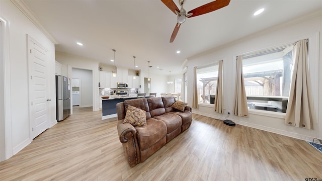 living room featuring ceiling fan, crown molding, and light hardwood / wood-style floors