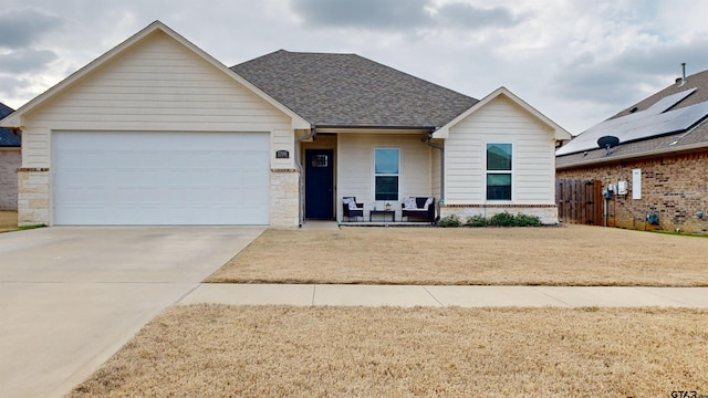 view of front of house featuring a front yard, a porch, and a garage