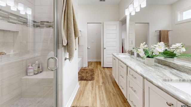 bathroom featuring hardwood / wood-style floors, an enclosed shower, and vanity