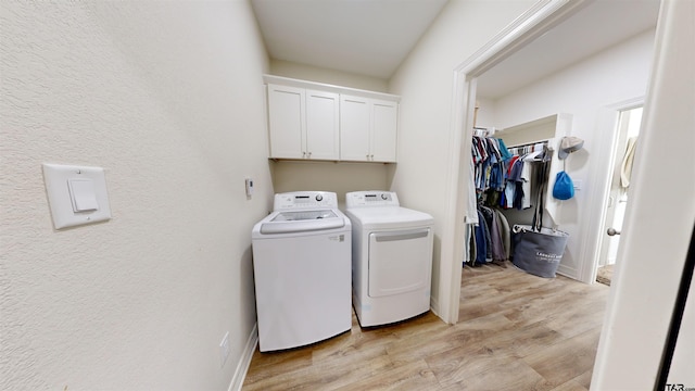 laundry area featuring light wood-type flooring, cabinets, and independent washer and dryer