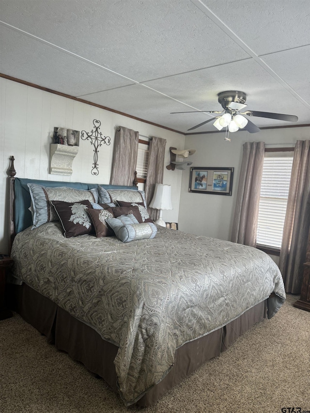 bedroom with crown molding, ceiling fan, carpet floors, and a textured ceiling