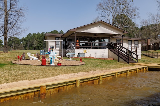 exterior space featuring stairway, a yard, and a water view