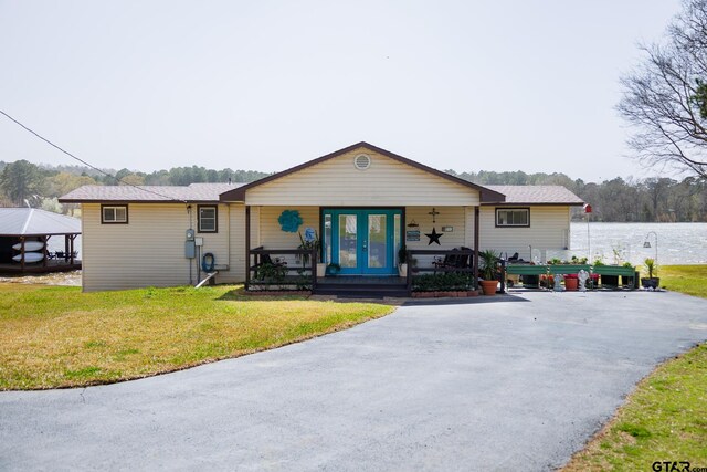 view of front of home with a front lawn and french doors