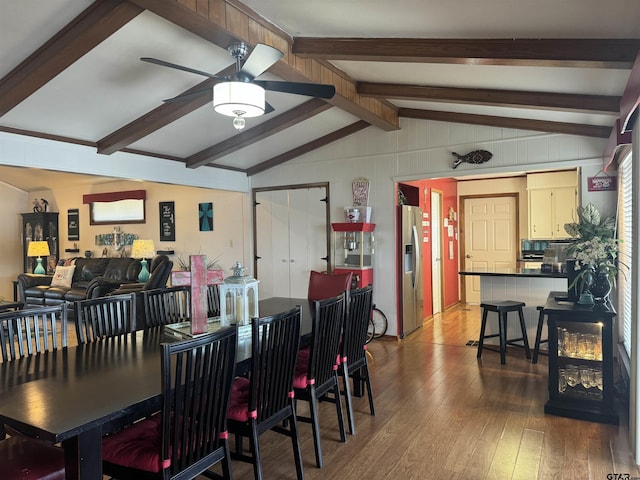 dining room with dark hardwood / wood-style flooring, vaulted ceiling with beams, and ceiling fan