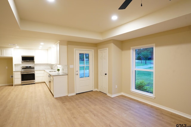 1370 Fm 315, Palestine, TX 75801 - kitchen with stainless steel appliances, a sink, decorative backsplash, a ceiling fan, and light wood finished floors