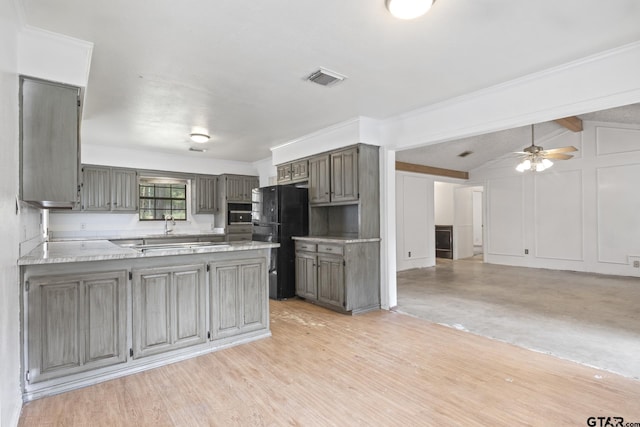 kitchen with visible vents, a peninsula, gray cabinets, freestanding refrigerator, and light countertops