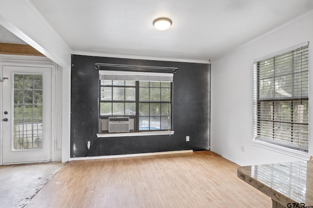 spare room featuring ornamental molding, wood finished floors, and a healthy amount of sunlight