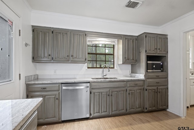 kitchen featuring a sink, stainless steel appliances, visible vents, and crown molding