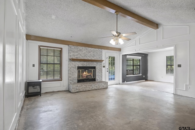 unfurnished living room featuring a brick fireplace, concrete floors, lofted ceiling with beams, a textured ceiling, and a ceiling fan