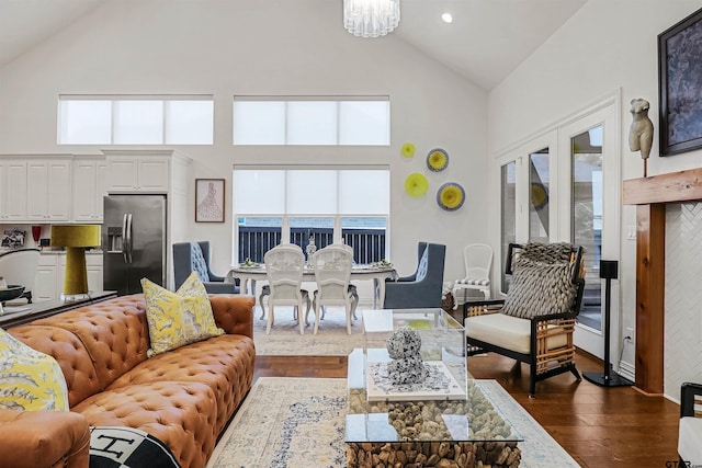 living room with dark hardwood / wood-style flooring, a high ceiling, and a notable chandelier