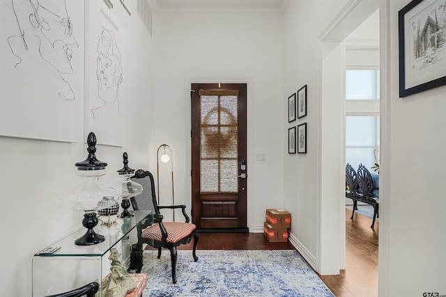 foyer entrance featuring dark hardwood / wood-style flooring and crown molding