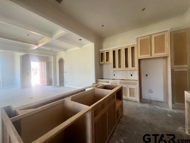 kitchen featuring coffered ceiling, cream cabinets, and beam ceiling