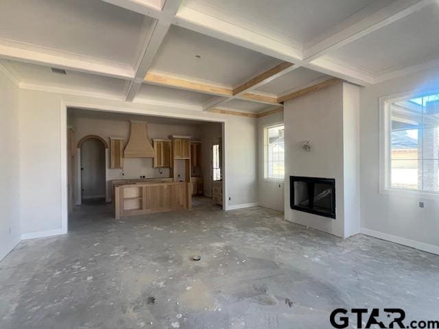 unfurnished living room featuring beam ceiling and coffered ceiling