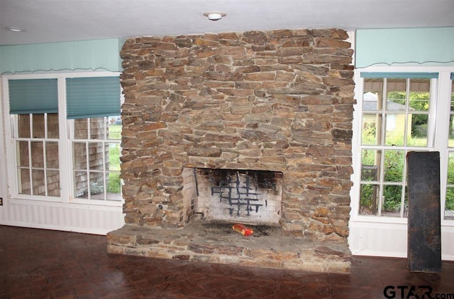 room details featuring a stone fireplace and parquet floors