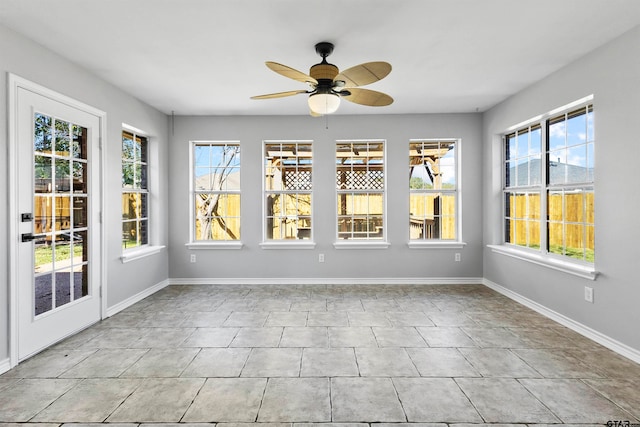 unfurnished sunroom with ceiling fan and a healthy amount of sunlight