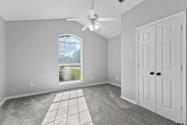 spare room featuring ceiling fan, lofted ceiling, and dark carpet