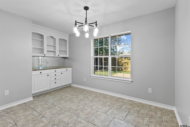 unfurnished dining area featuring a chandelier and light tile patterned floors