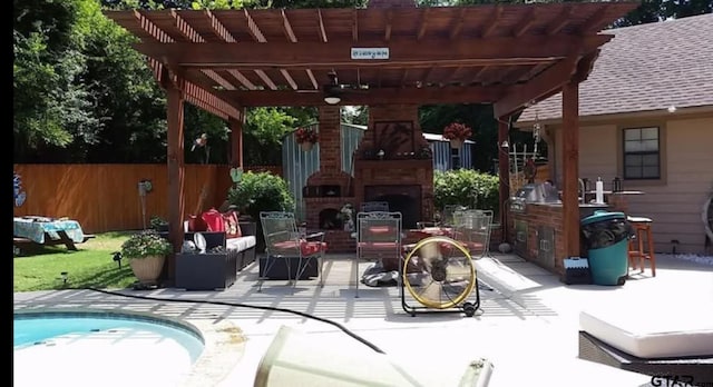 view of patio / terrace featuring fence, an outdoor fireplace, and a pergola