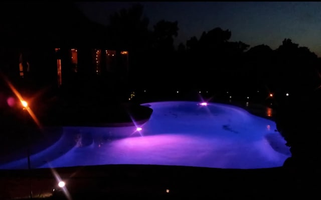 pool at night with an outdoor pool