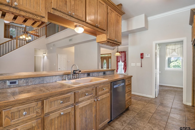 22886 County Road 422, Lindale, TX 75771 - kitchen with stainless steel dishwasher, brown cabinetry, crown molding, tile patterned floors, and tile countertops