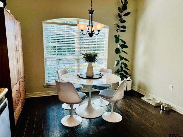 dining space with dark hardwood / wood-style floors and an inviting chandelier