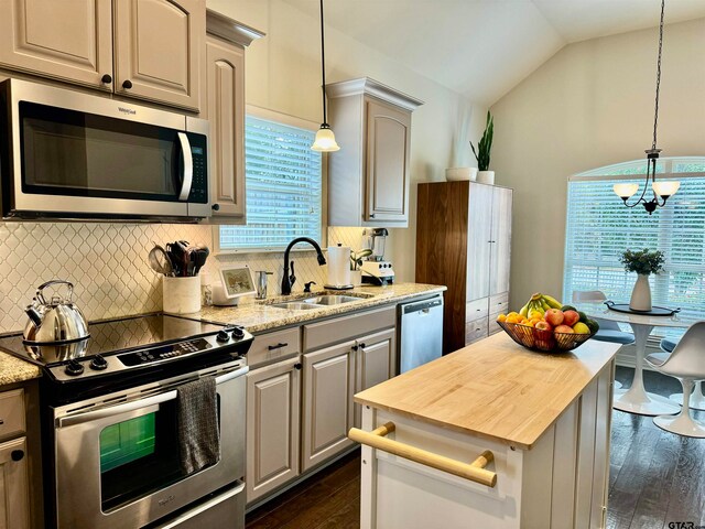 kitchen with dark wood-type flooring, sink, stainless steel appliances, and lofted ceiling