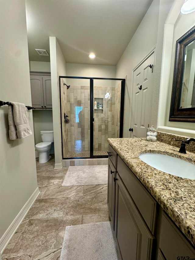 bathroom featuring vanity, toilet, and walk in shower