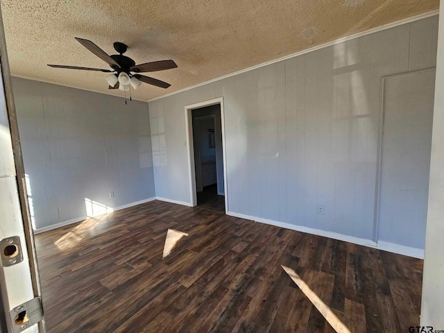 unfurnished room with a textured ceiling, ceiling fan, crown molding, and dark wood-type flooring